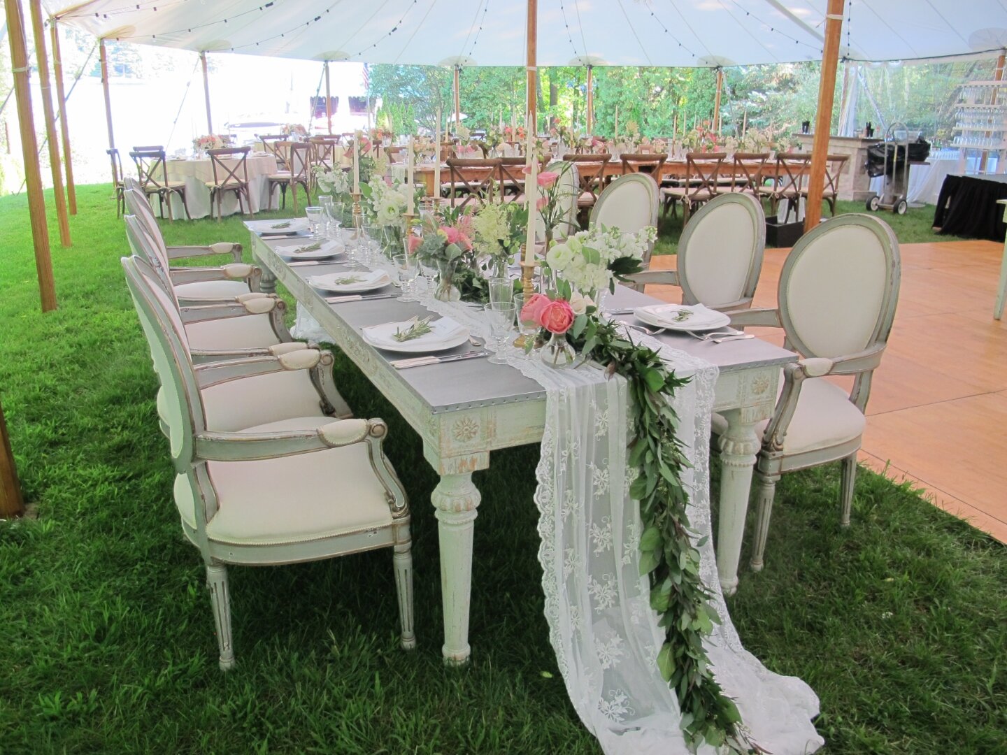 Sailcloth tent over a long farm table set for a wedding party